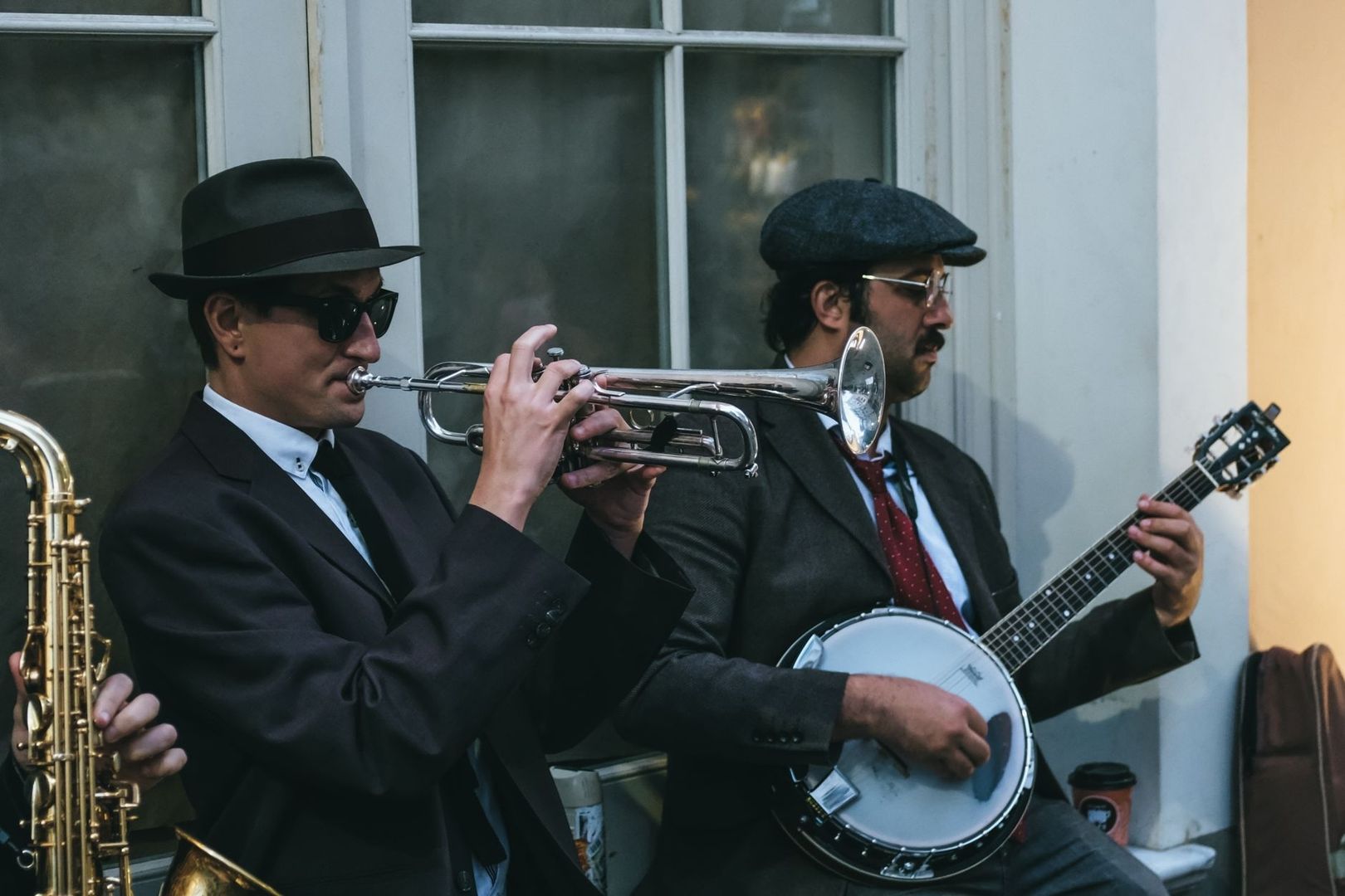 Two vintage-styled jazz musicians playing trumpet and banjo outdoors