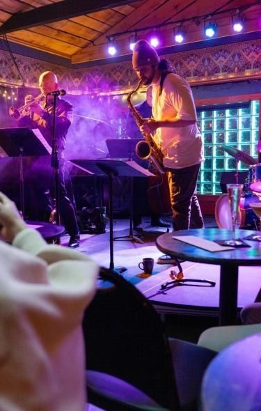 Jazz musicians perform together on a warmly lit club stage